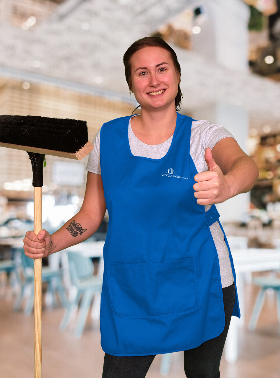 Eine Mitarbeiterin der Gastroreinigung München mit blauer Weste, Besen und Daumen noch
