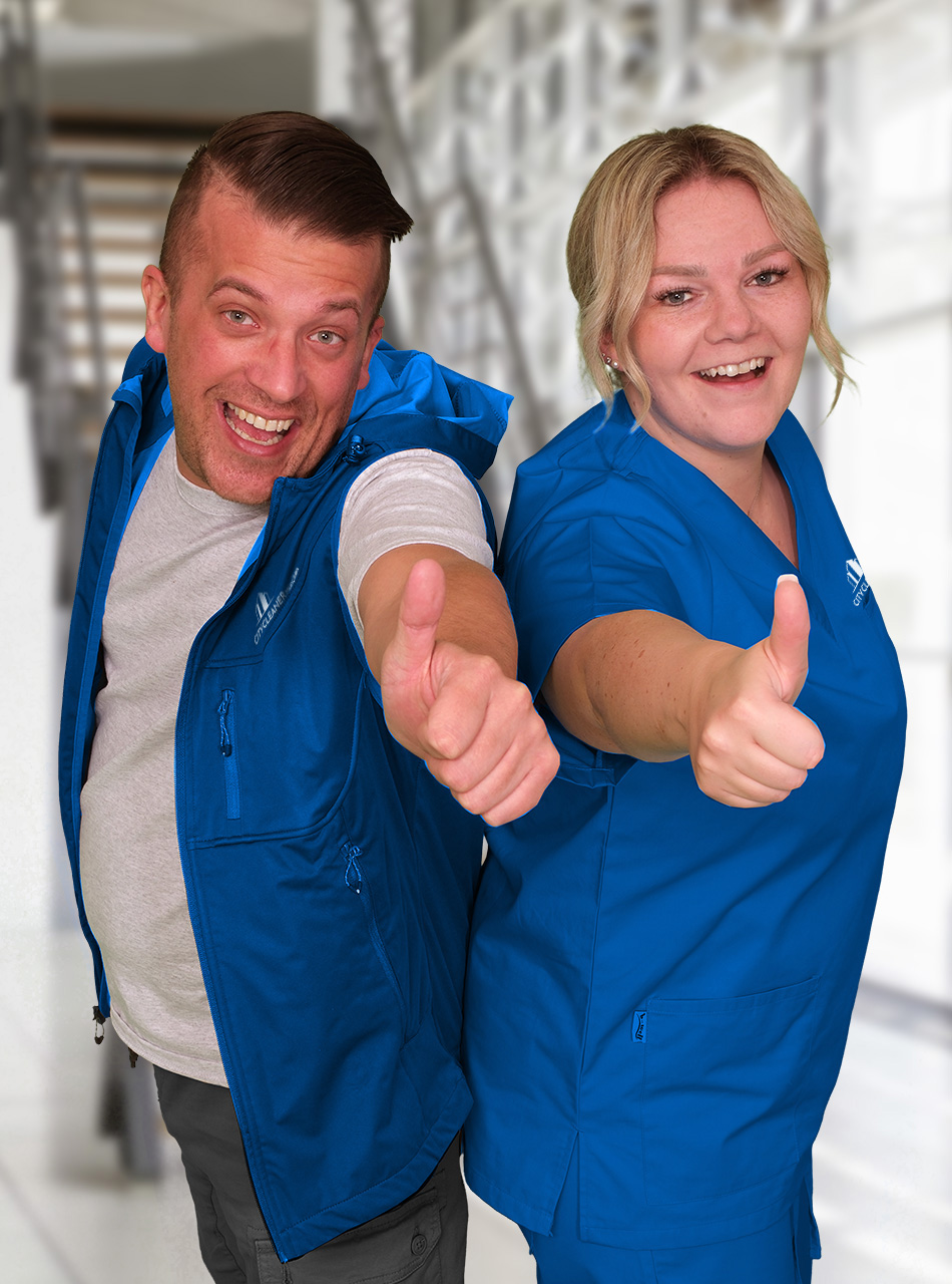 Zwei Mitarbeiter der Hausmeisterservice in blauer Arbeitskleidung mit Daumen hoch