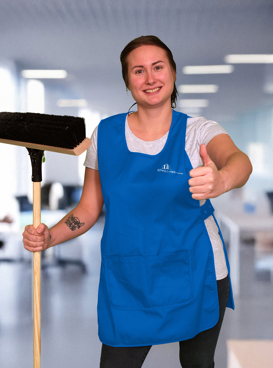 Eine Mitarbeiterin der Büroreinigung München mit blauer Weste, Besen und Daumen noch